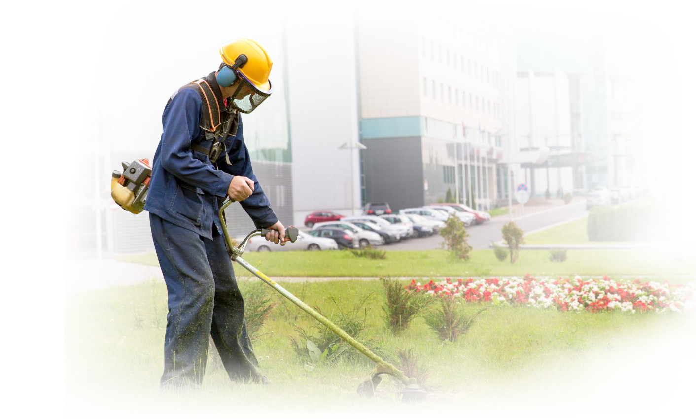 Man using weed wacker to trim grass on project site